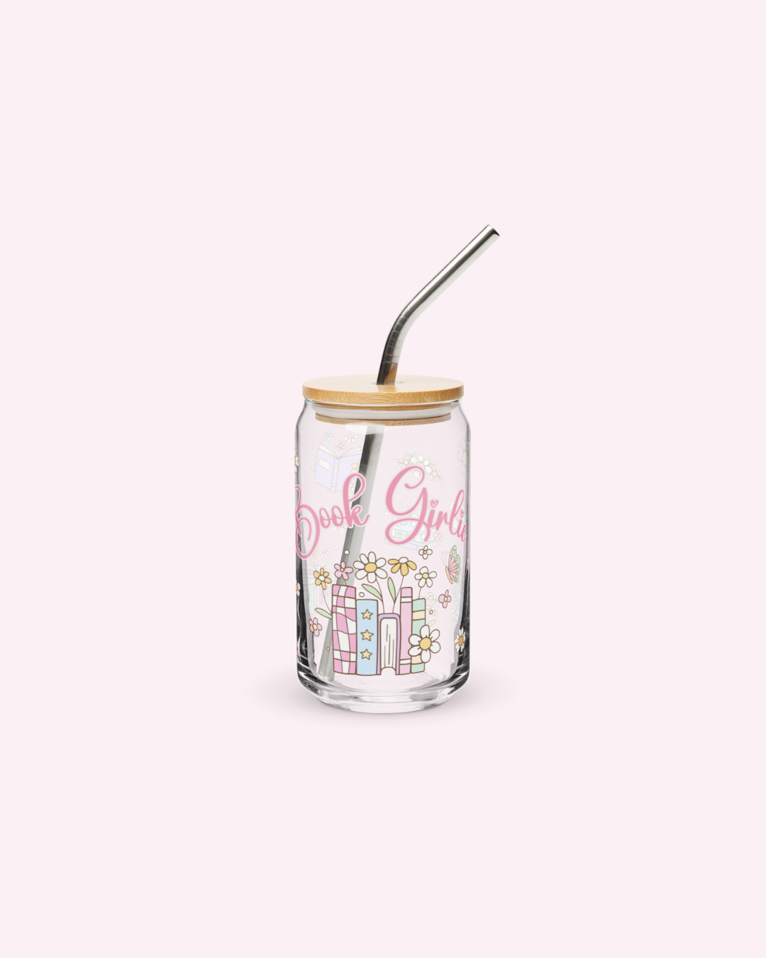 A clear bookish glassware with pink book girlie text and floral designs, a wooden lid, and a silver metallic straw.
