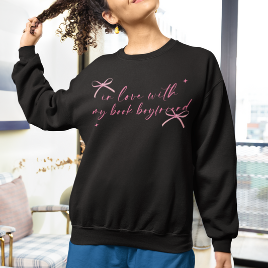 Person wearing a black sweatshirt with pink text in a casual indoor setting