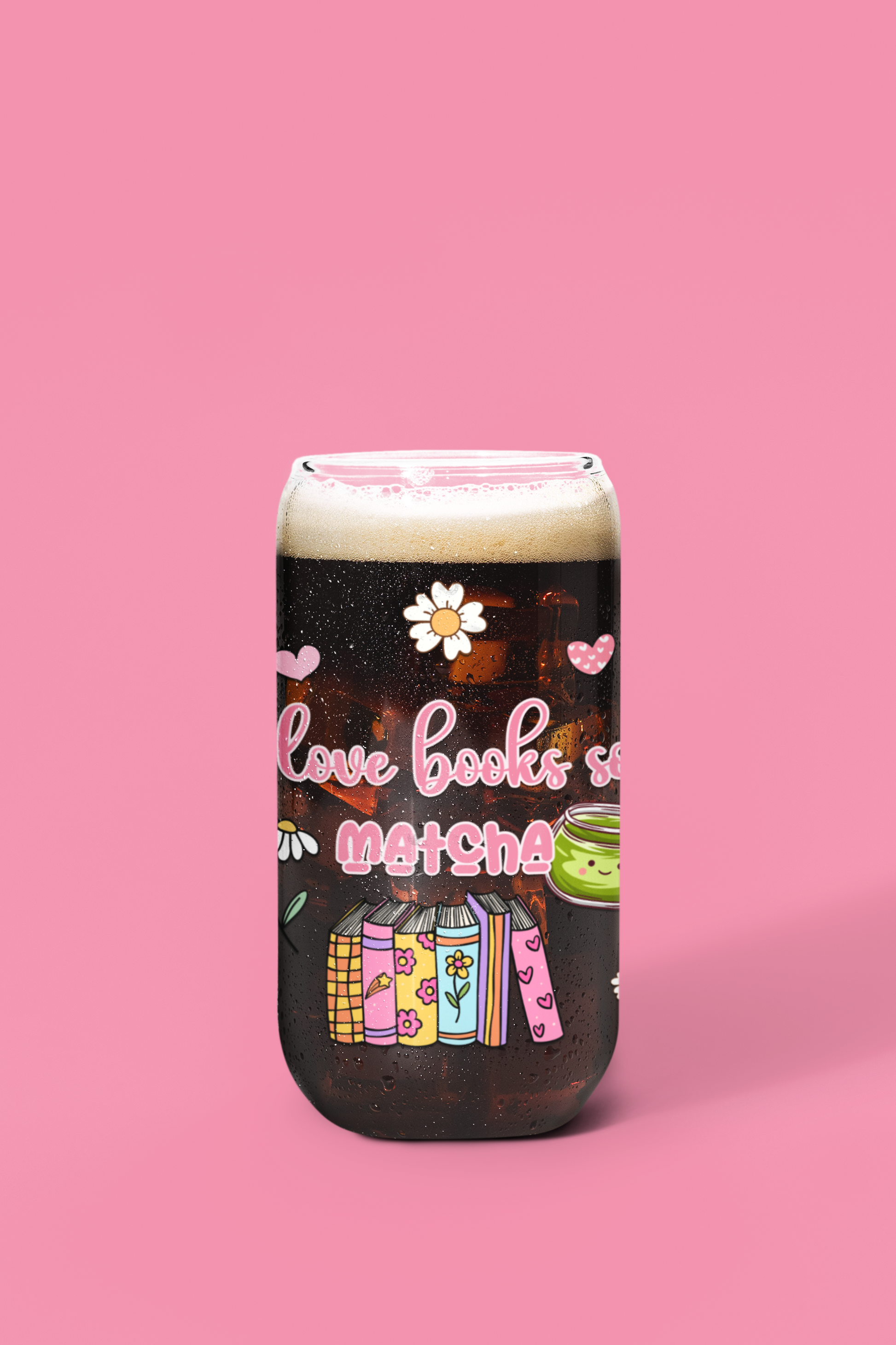 A glass can with a design that includes text 'I love books so matcha' and illustrations of books and a cup of matcha. bookish glassware for matcha lovers